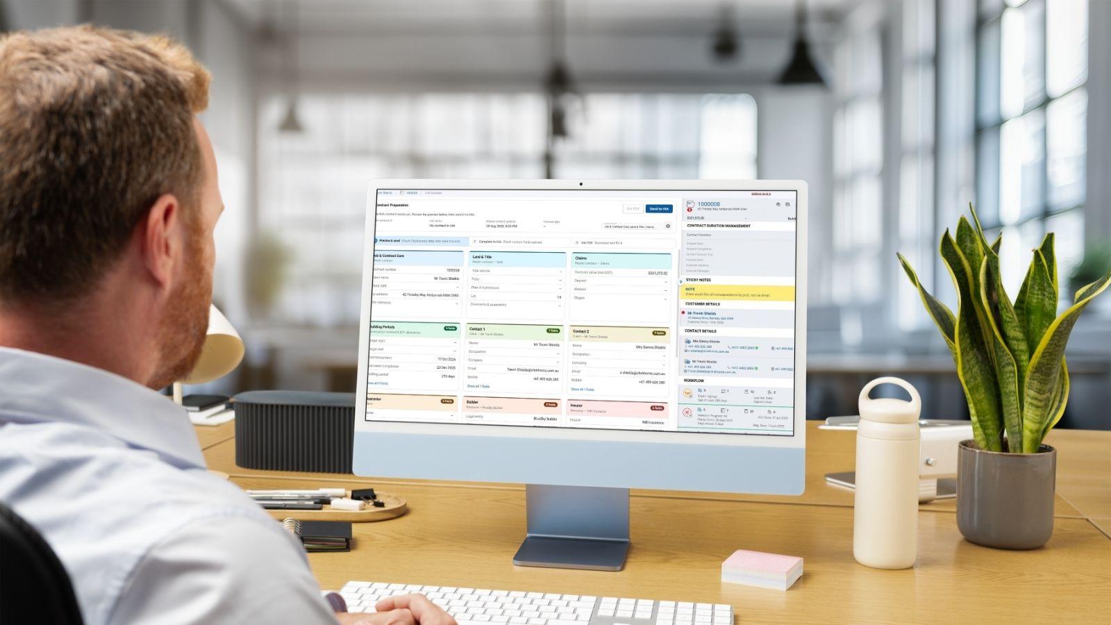 A builder at a desktop computer using ClickHome27’s contract preparation screen to send job details to HIA